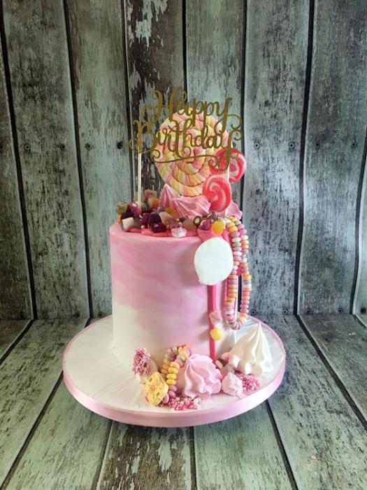 chocolate drip cake with sweets and merangues birthday cake