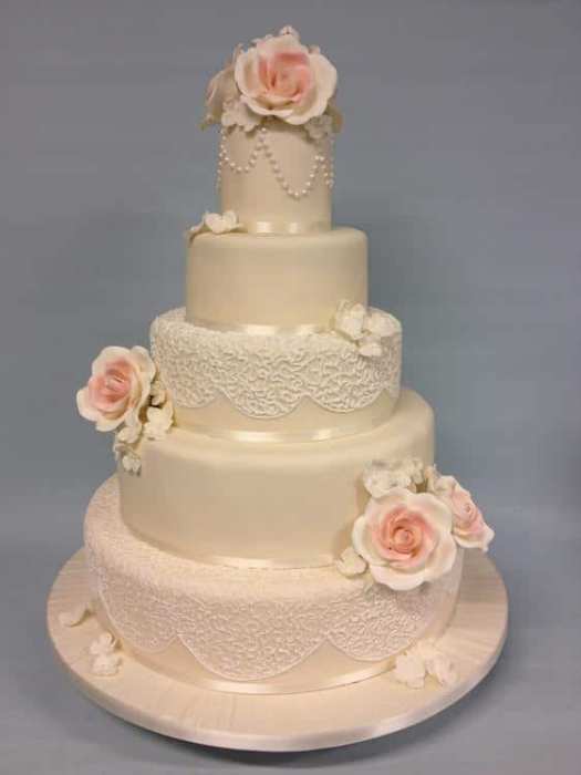 Extra large wedding cake personalised with initials of the couple sugar flowers hand piped pearls and old fashioned drop lines for for a truly timeless piece