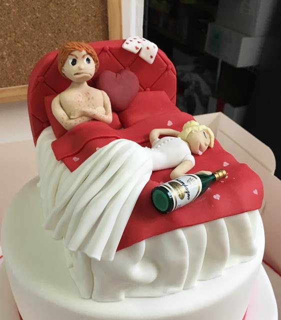bride and groom in bed cake topper