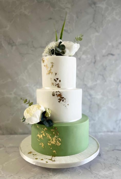 ced wedding cake with silk flowers and sage green  base with gold leaf