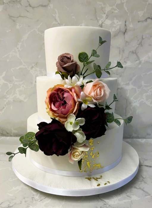 Iced-wedding-cake-with-gold-leaf-and-silk-flowers-